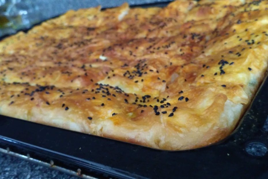 Tepsi böreği tarifi: Fırında pişmiş, peynir dolgulu ve üzeri çıtır kızarmış hazır yufkadan börek dilimleri.