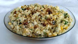 Yoğurtlu bulgur salatası, mısır, turşu ve maydanozla süslenmiş.