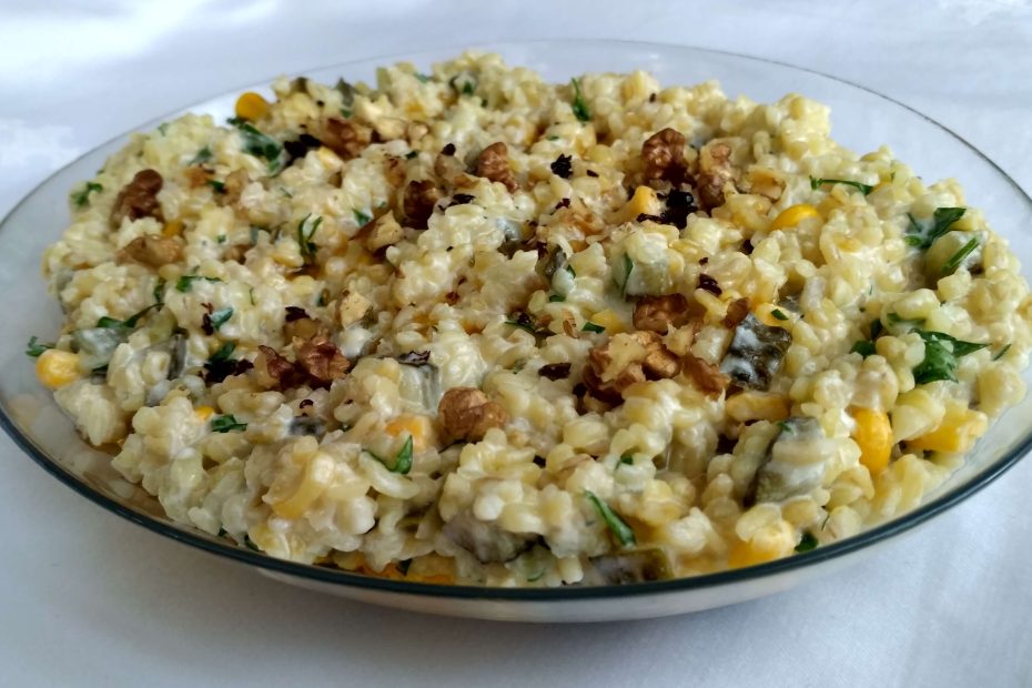 Yoğurtlu bulgur salatası, mısır, turşu ve maydanozla süslenmiş.