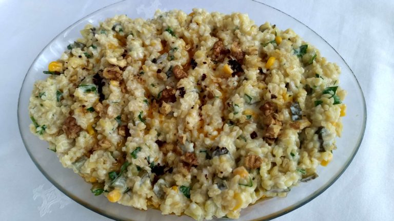 Yoğurtlu cevizli bulgur salatası, maydanoz ve yoğurtla servis edilmiş.
